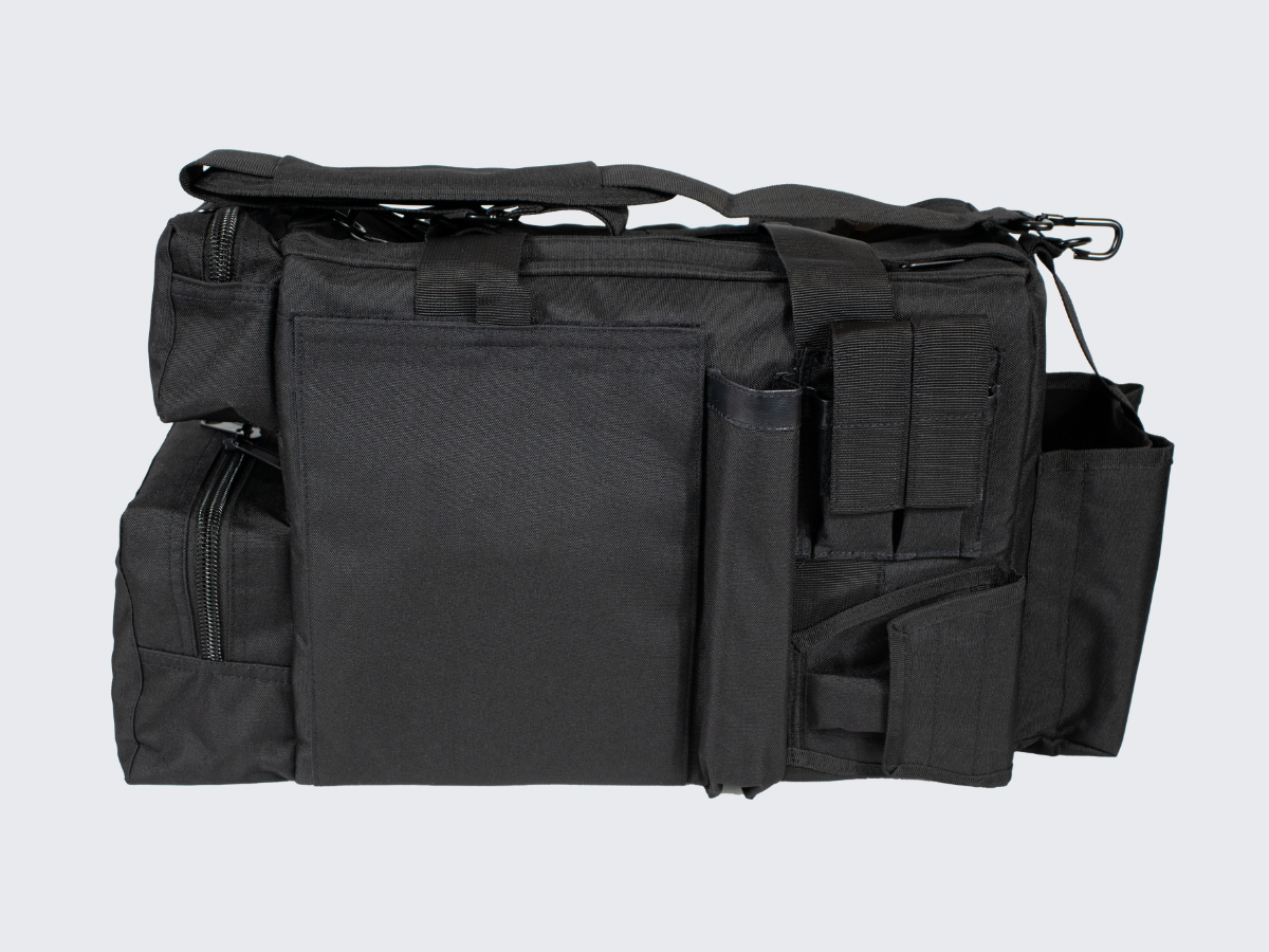 Musta varustelaukku useilla vetotetjullisilla varustetaskuilla. Svart utrustningsväska med flera fickor med dragkedjor. Black gear bag with multiple zippered compartments.