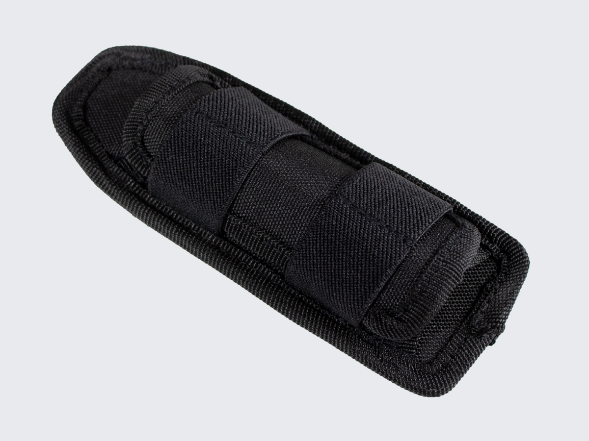 Pienikokoinen ja kevyt taskulampunpidike vartijoille ja järjestyksenvalvojille varustevyölle MOLLE kiinnityksellä. Compact and lightweight flashlight holder for guards and security personnel on their utility belts with MOLLE attachement.