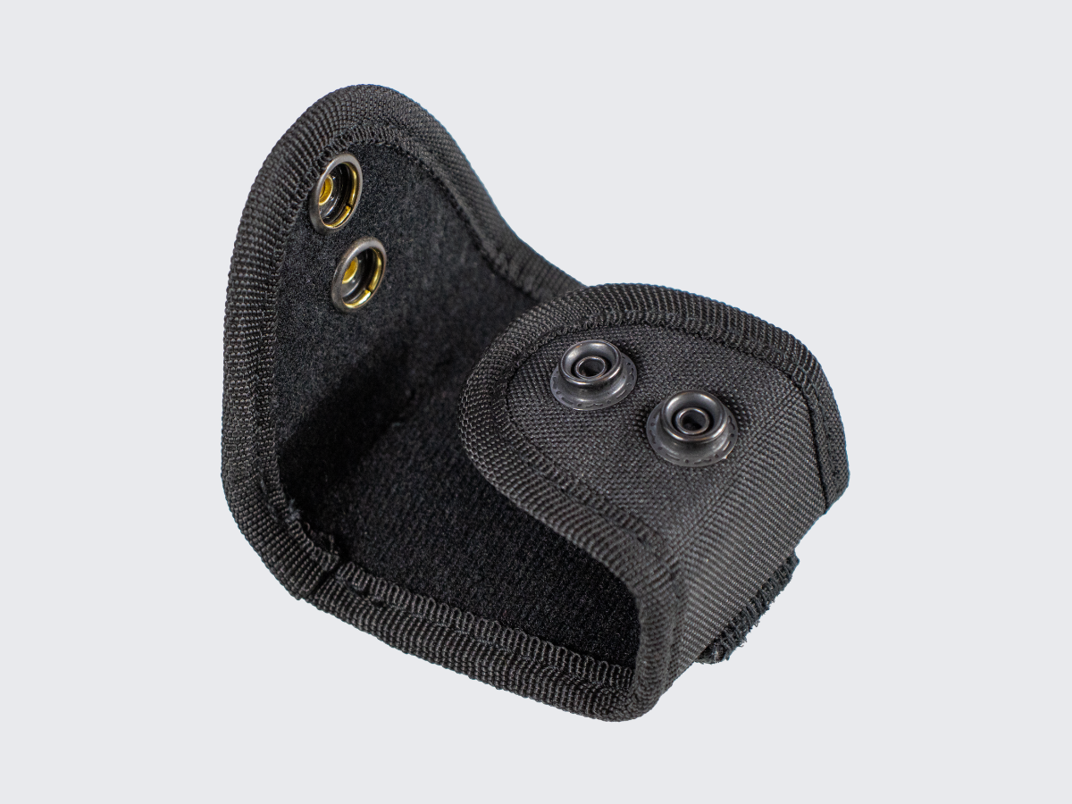 Pienikokoinen ja erittäin kevyt käsirautapidike vartijan tai järjestyksenvalvojan varustevyölle. A compact and extremely lightweight handcuff holder for a guard or security personnel equipment belt.