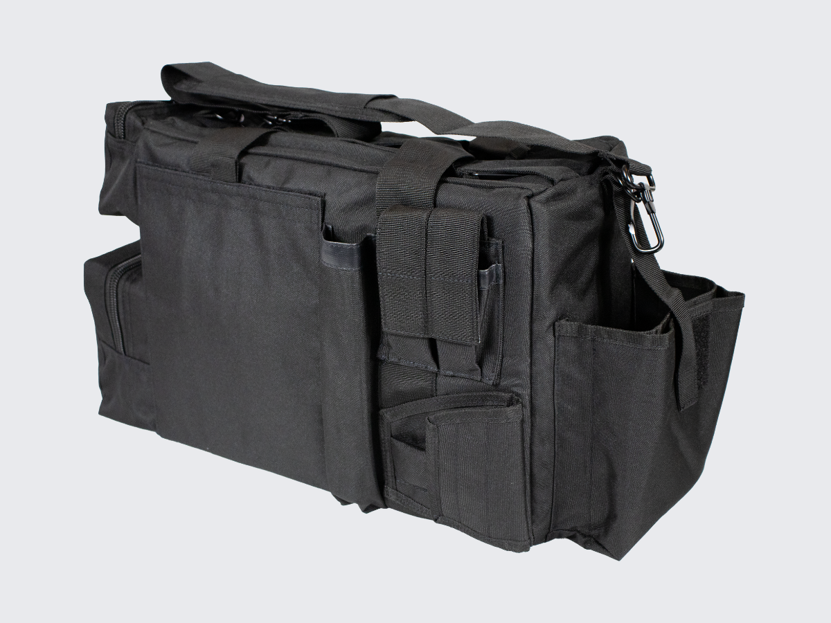 Musta varustelaukku useilla vetotetjullisilla varustetaskuilla. Svart utrustningsväska med flera fickor med dragkedjor. Black gear bag with multiple zippered compartments.