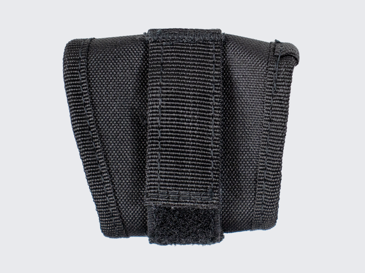 Pienikokoinen ja erittäin kevyt käsirautapidike vartijan tai järjestyksenvalvojan varustevyölle. A compact and extremely lightweight handcuff holder for a guard or security personnel equipment belt.