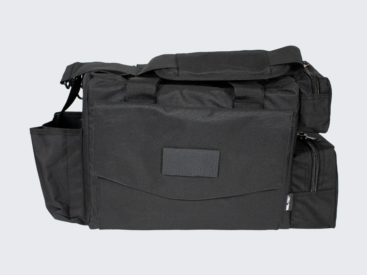 Musta varustelaukku useilla vetotetjullisilla varustetaskuilla. Svart utrustningsväska med flera fickor med dragkedjor. Black gear bag with multiple zippered compartments.