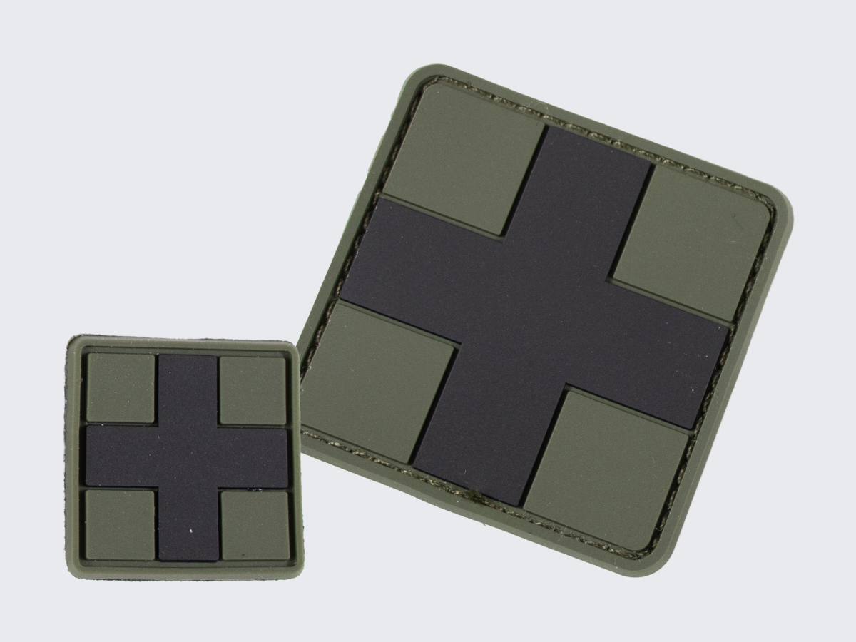 Vihreä PVC hihamerkki tummalla ristillä. Kaksi eri kokoa. Green PVC patch with a dark cross. Two different sizes.